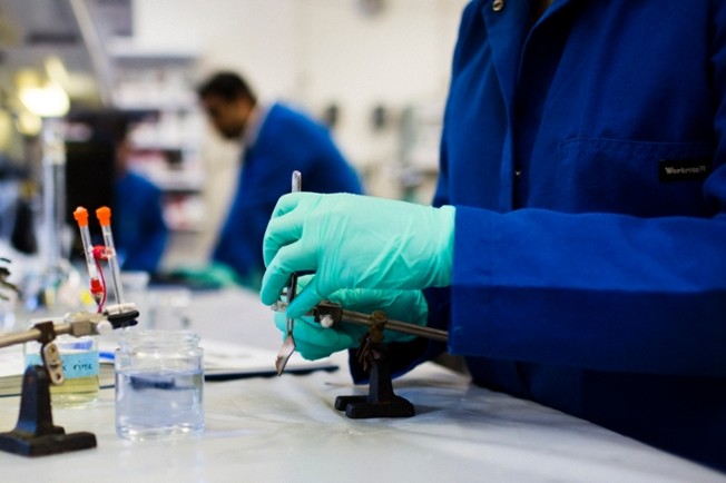 a students hands are focused on as they work in the lab leveraged research