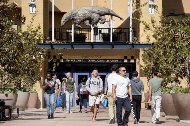 students walk in front of the UCI student center